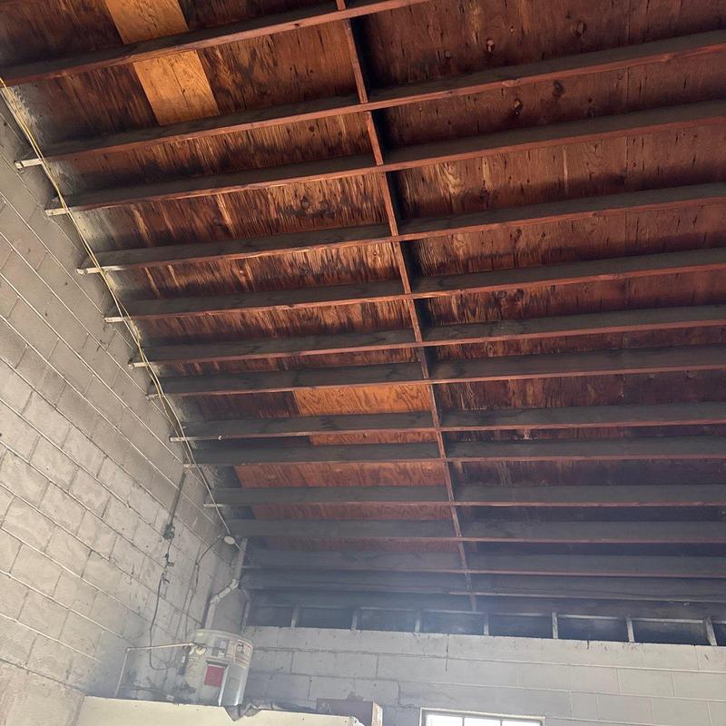 Exposed wooden ceiling joists and roof structure in garage