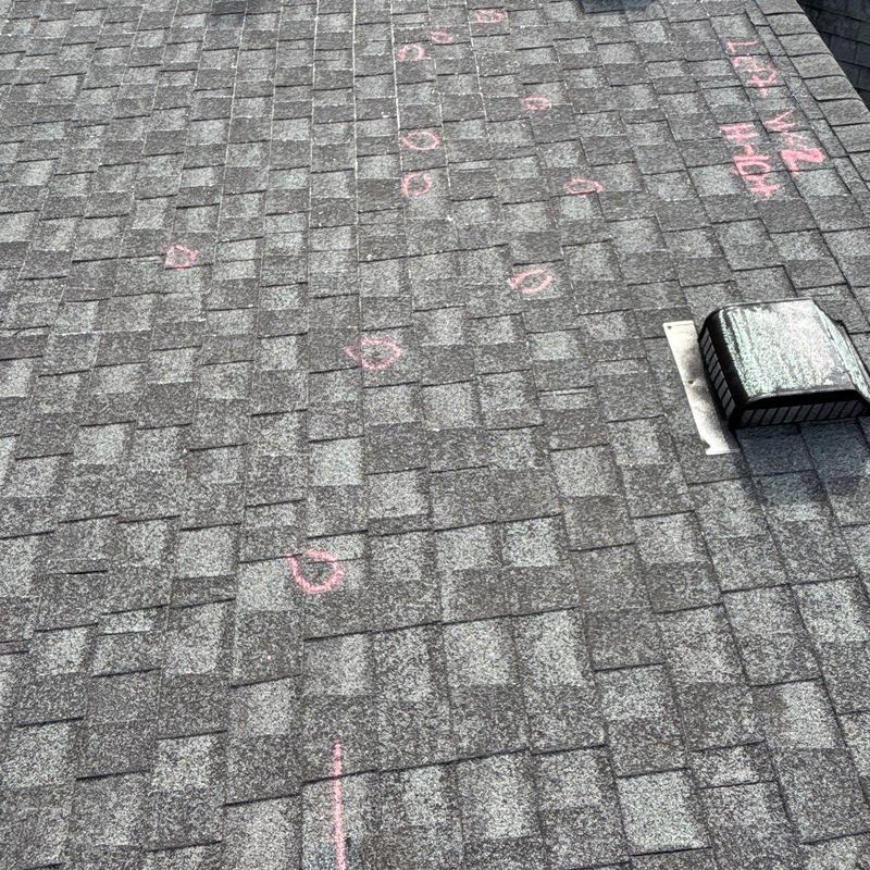 Asphalt shingles with marked hail damage and vent pipe