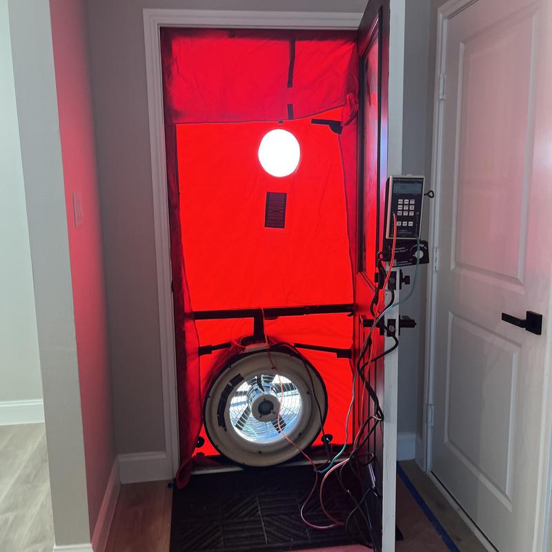 Blower door testing setup on residential front door