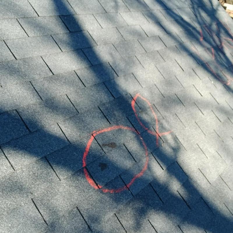 Roof shingles with marked damage spots and shadows