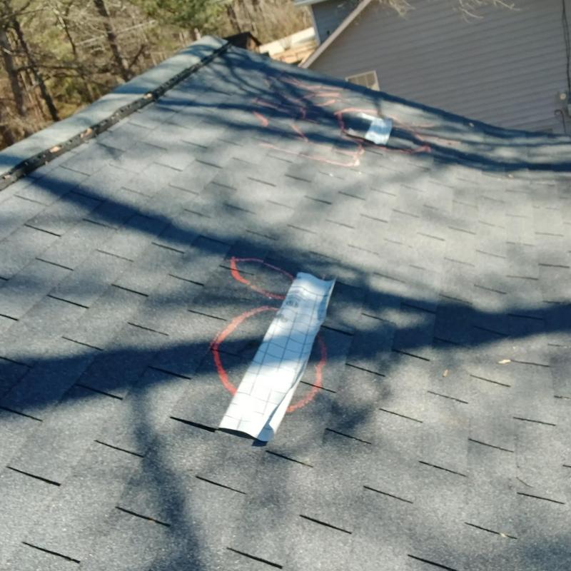 Damaged roof shingles with protective tarps installed