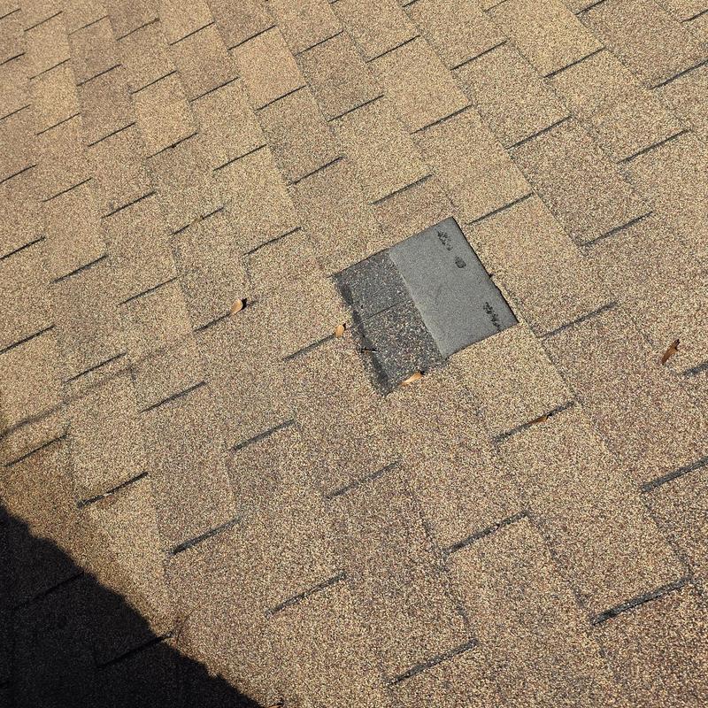 Asphalt shingle roof with hail damage and replacement shingle