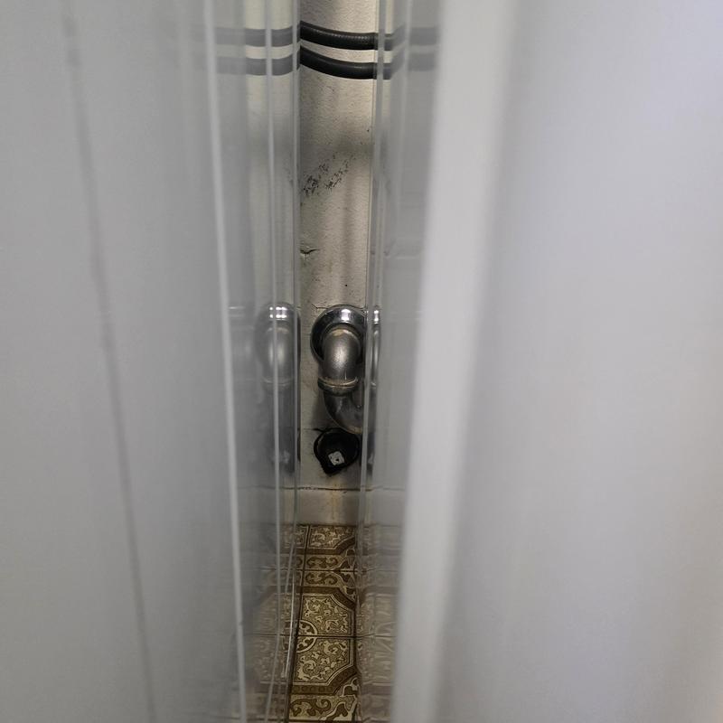 Washer drain pipe with blockage access behind washer