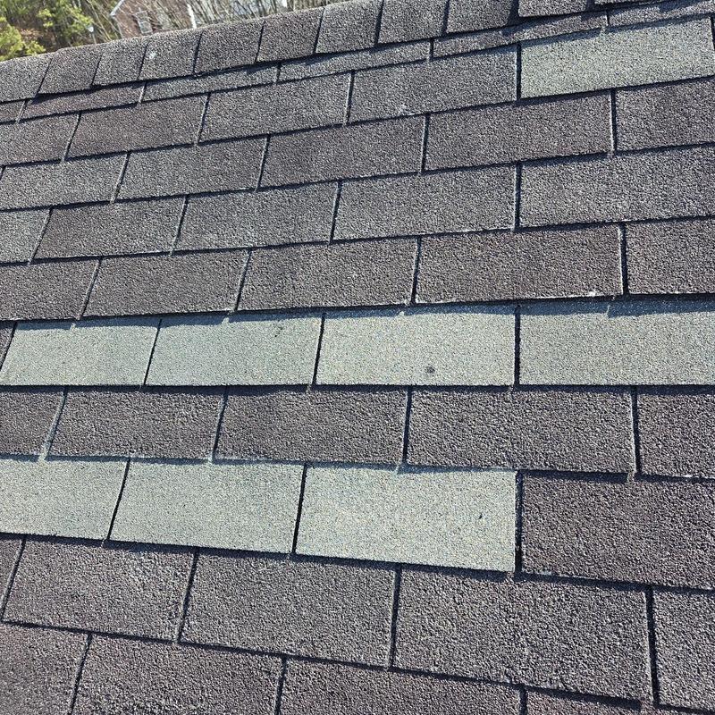 Asphalt shingles with replaced ridge caps and caulking