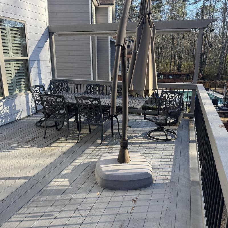 Wood deck with metal patio furniture and umbrella base