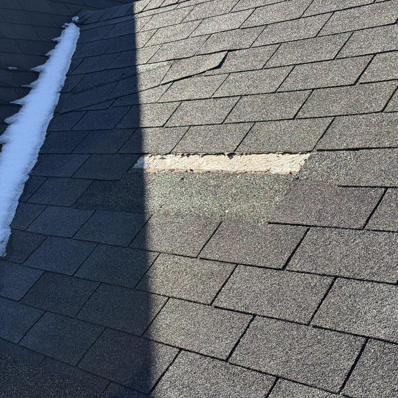 Missing slate shingles on roof with shadow and snow strip