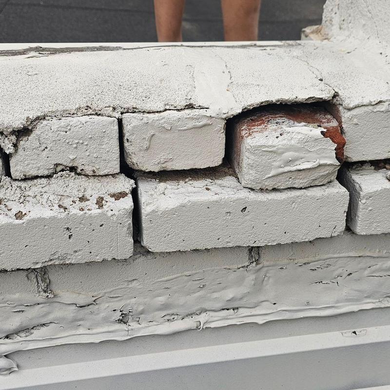 Parapet wall masonry with surface damage and gaps Parapet wall masonry with surface damage and gaps