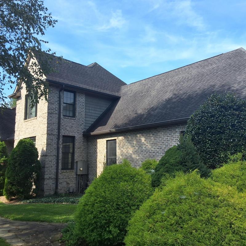 Asphalt shingle roof on brick home with landscaping