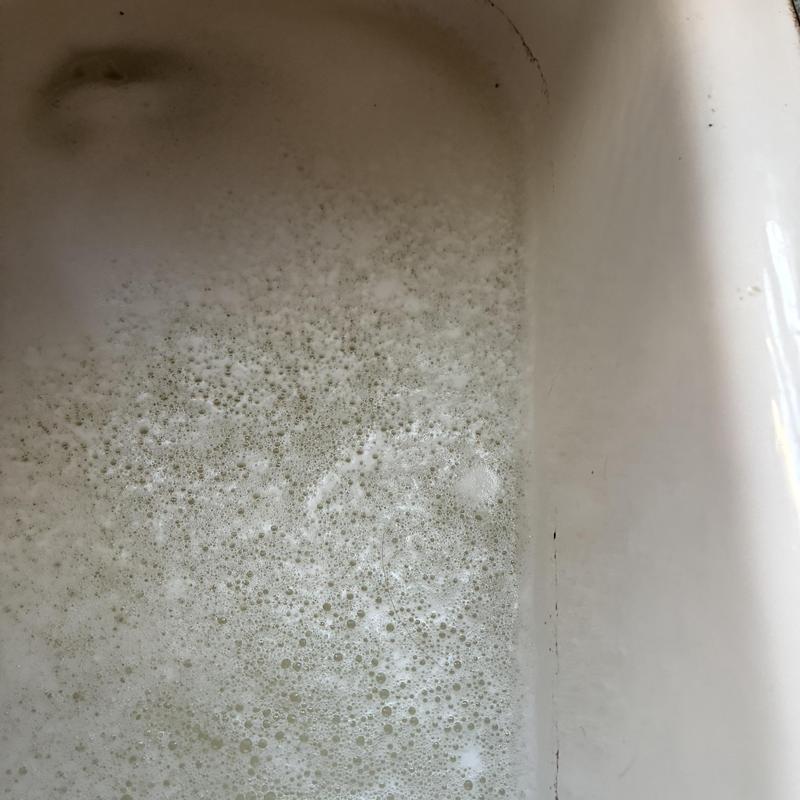 Kitchen sink drain with soap suds flooding basin