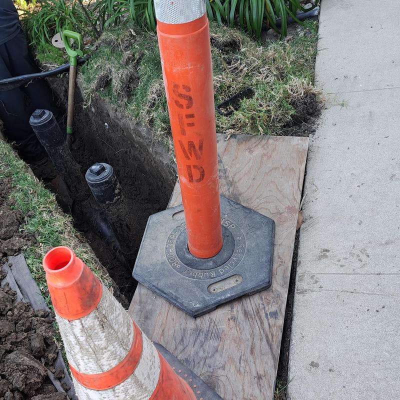 Sewer drain replacement with safety cones on site