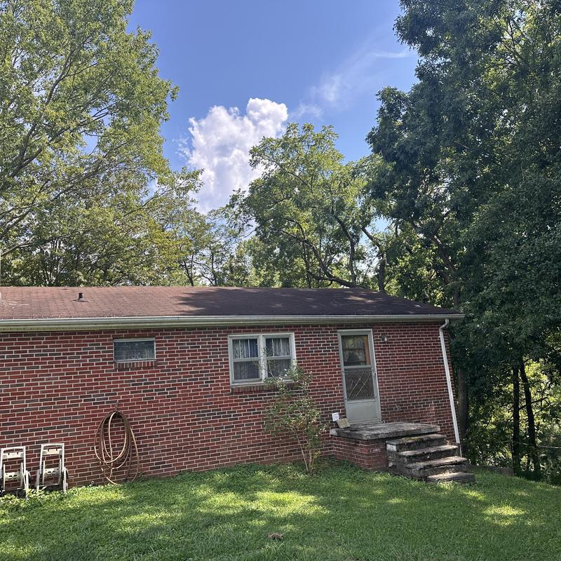 Brick chimney and black shingle roof exterior view