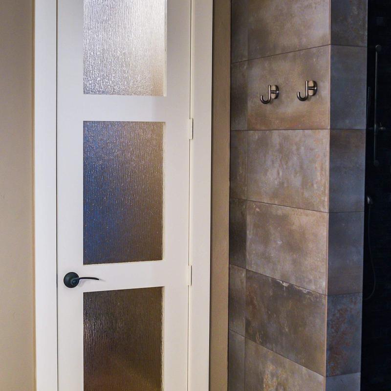 Frosted glass bathroom door with tile wall hooks