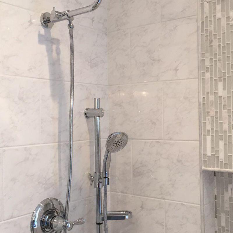 Master shower with handheld chrome showerhead and tile walls