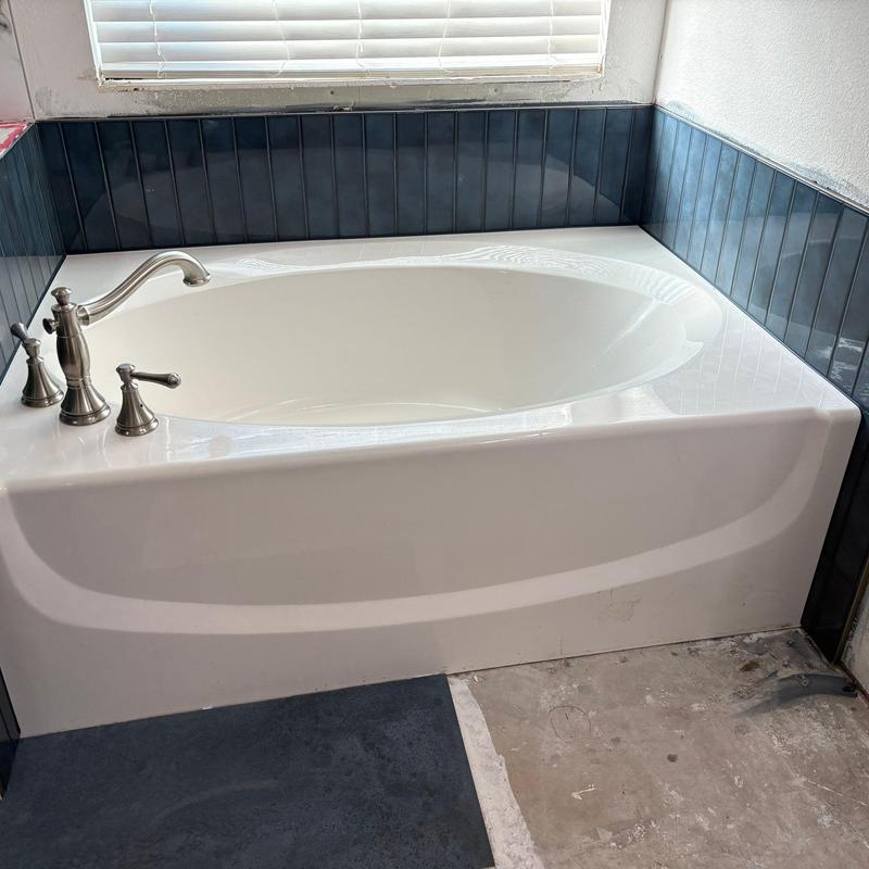 Master bathroom bathtub with dark tile surround