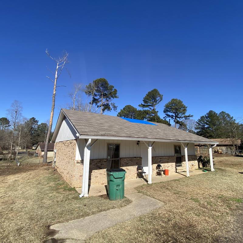Roof tarp installation over tree-damaged area Roof tarp installation over tree-damaged area