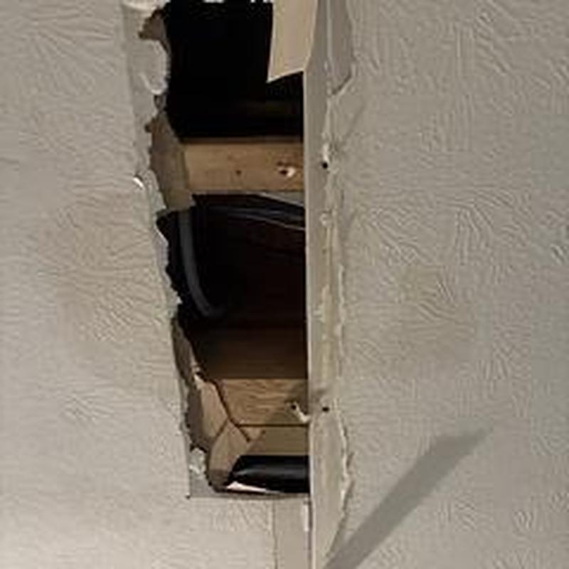 Tub drain pipes behind cut drywall opening