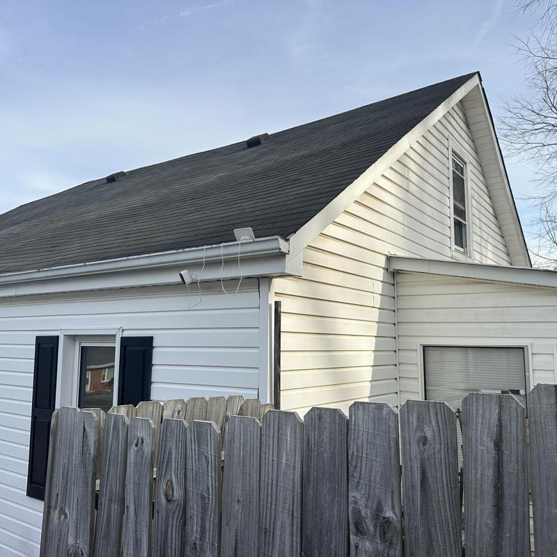 Asphalt shingle roof with 8/12 pitch on white house