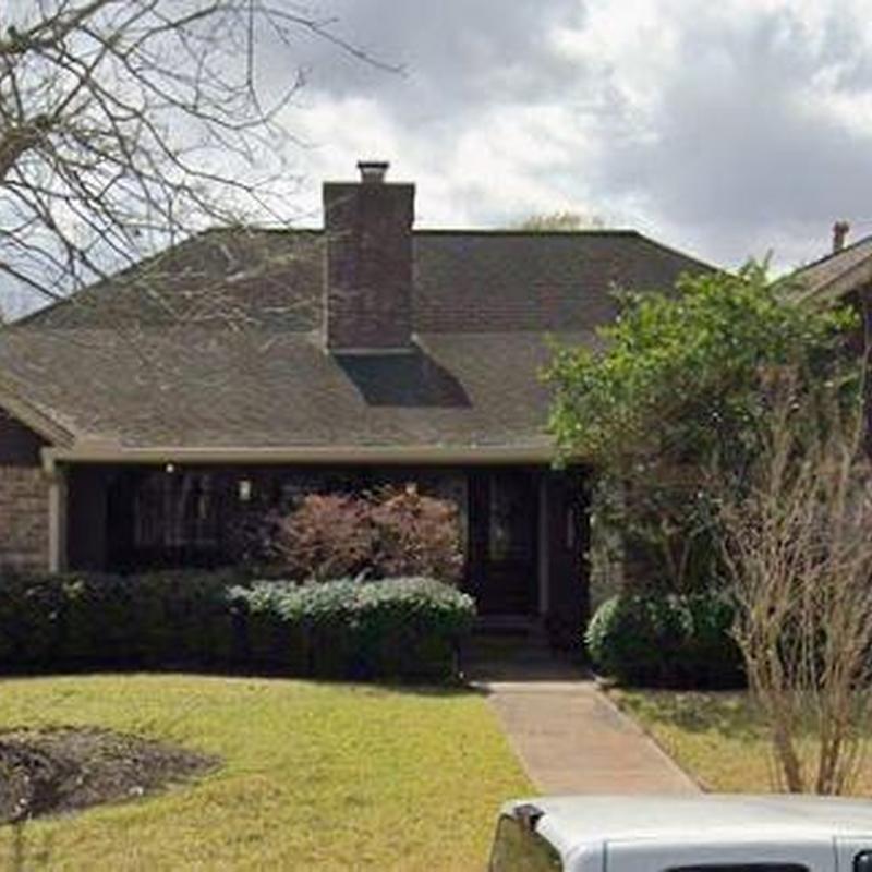 Residential roof and chimney inspection with landscaping view