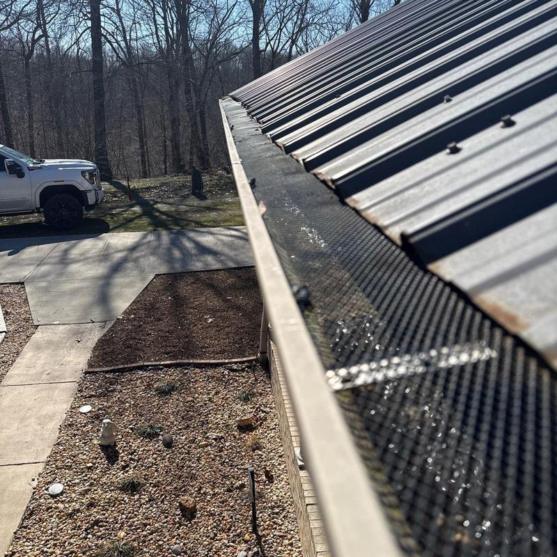 Gutter guard mesh installation on metal roof edge