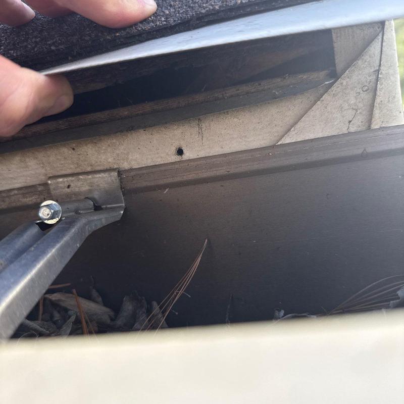 Roof ridge vent inspection showing flashing and shingles