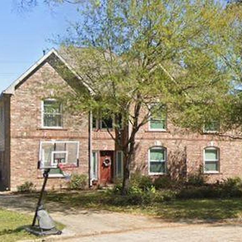 Brick house exterior with tree and basketball hoop