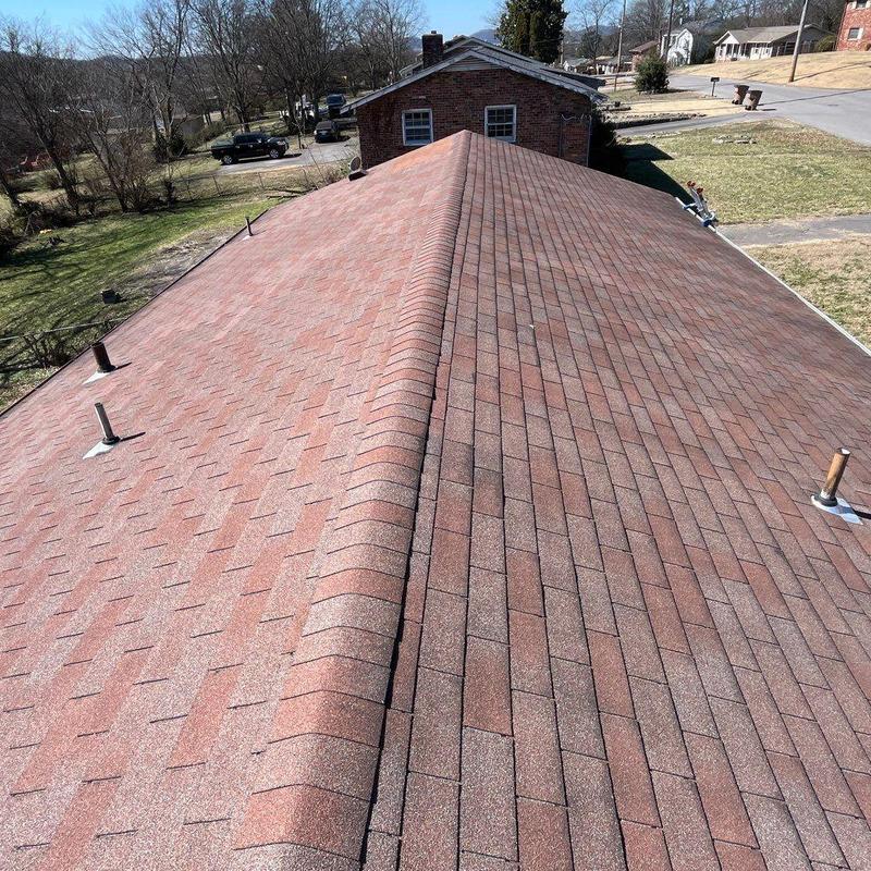Asphalt shingle roof with ridge cap and vent pipes