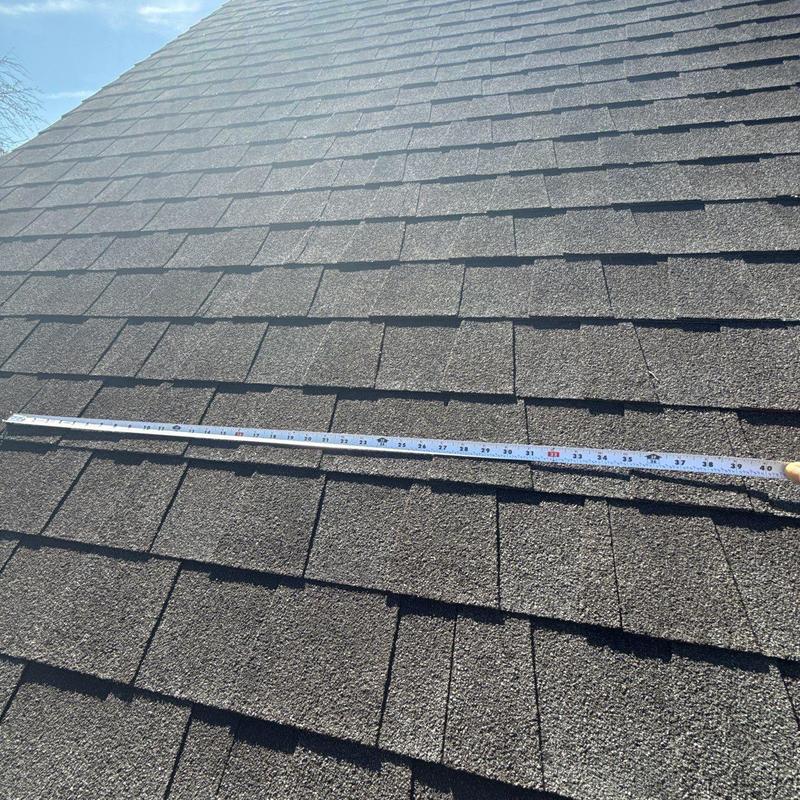 Asphalt shingle roof with measurement tape