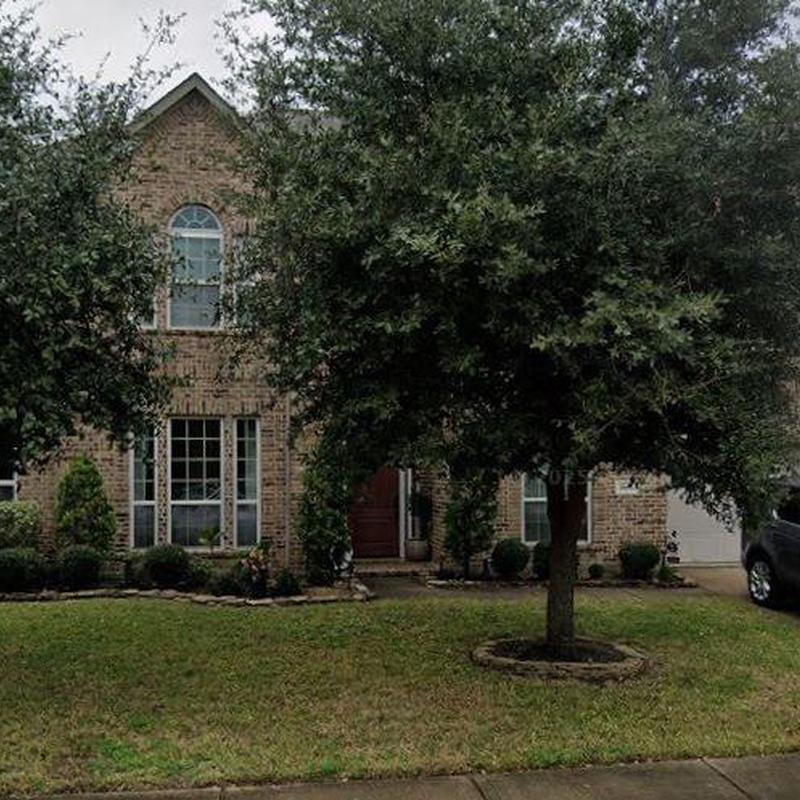 Brick house exterior with landscaping and lawn maintenance