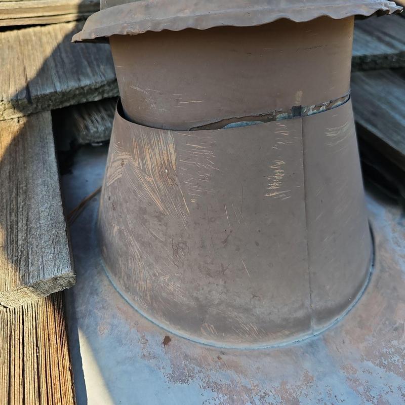 Metal roof vent with visible cracks and scratches Metal roof vent with visible cracks and scratches