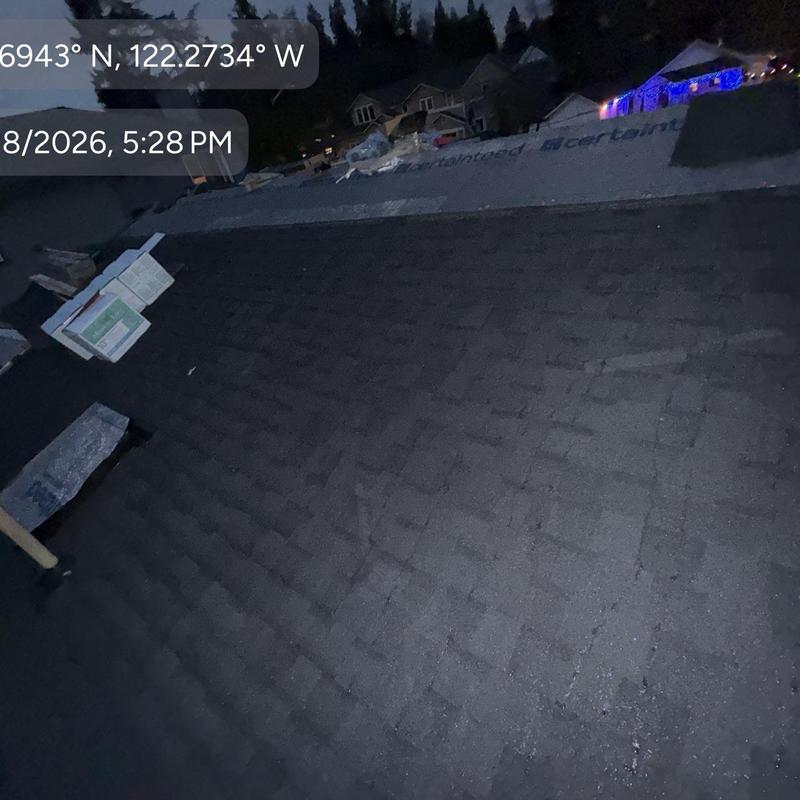 Asphalt shingle roof installation at night in Seattle