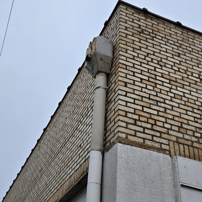 Metal gutter corner section on brick building exterior