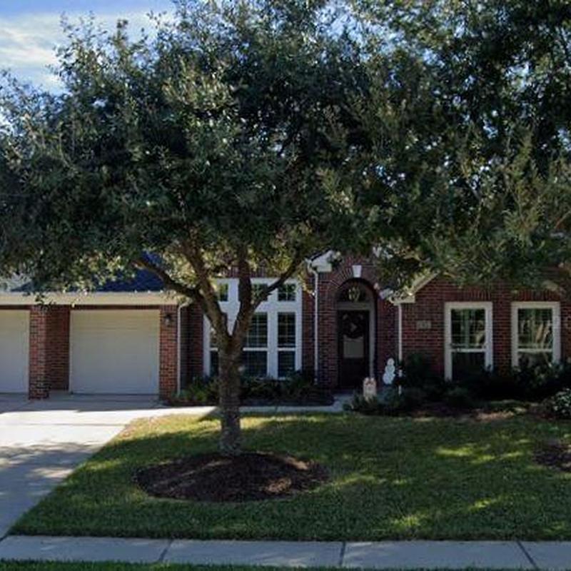Brick house exterior with tree and driveway in Katy, TX