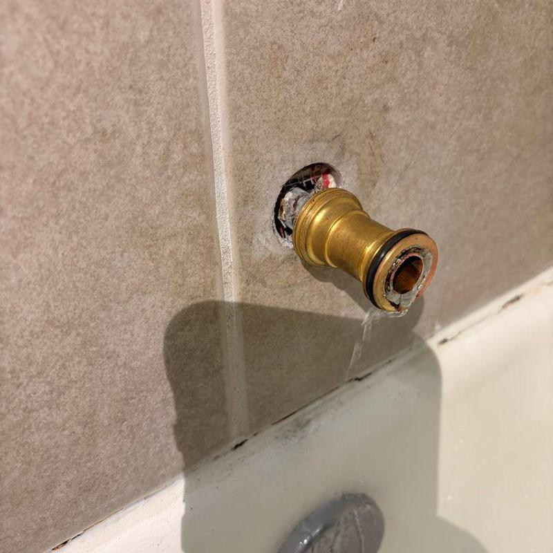 Tub spout pipe extension exposed in tiled wall hole