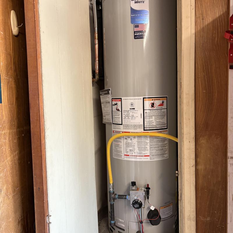 40 gallon gas water heater with yellow gas line in garage