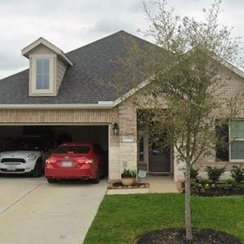 Asphalt shingle roof on suburban home with tree