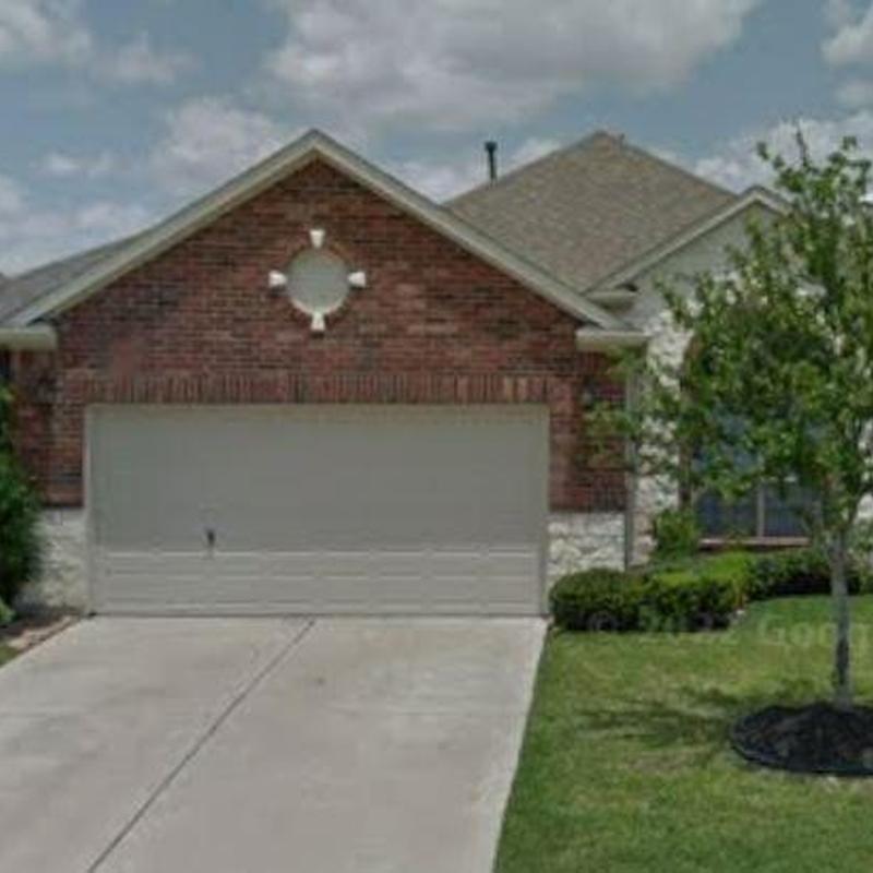Garage door and driveway with brick home exterior