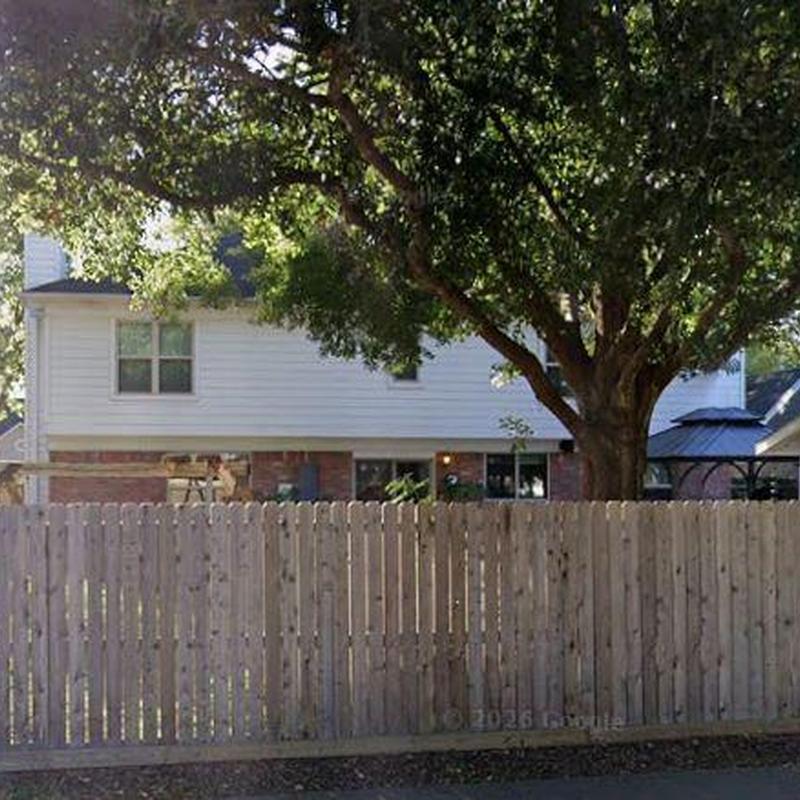 Wood privacy fence in residential backyard with trees
