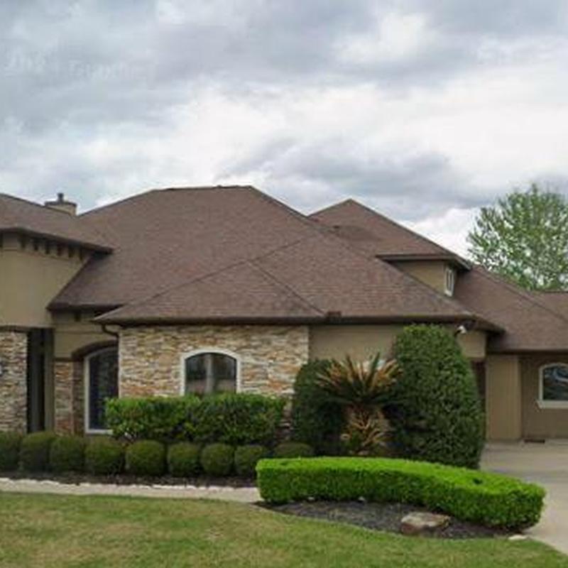 Asphalt shingle roof with stone facade and landscaping