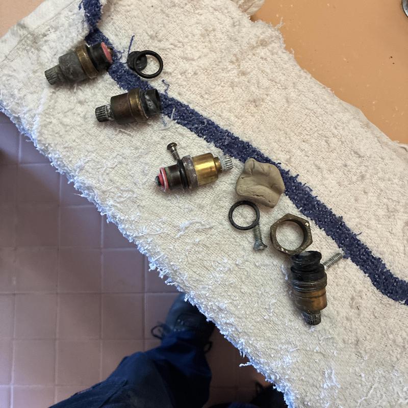Shower valve stems and faucet parts removed on towel