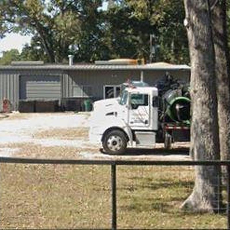 Commercial cement mixer truck parked by metal building