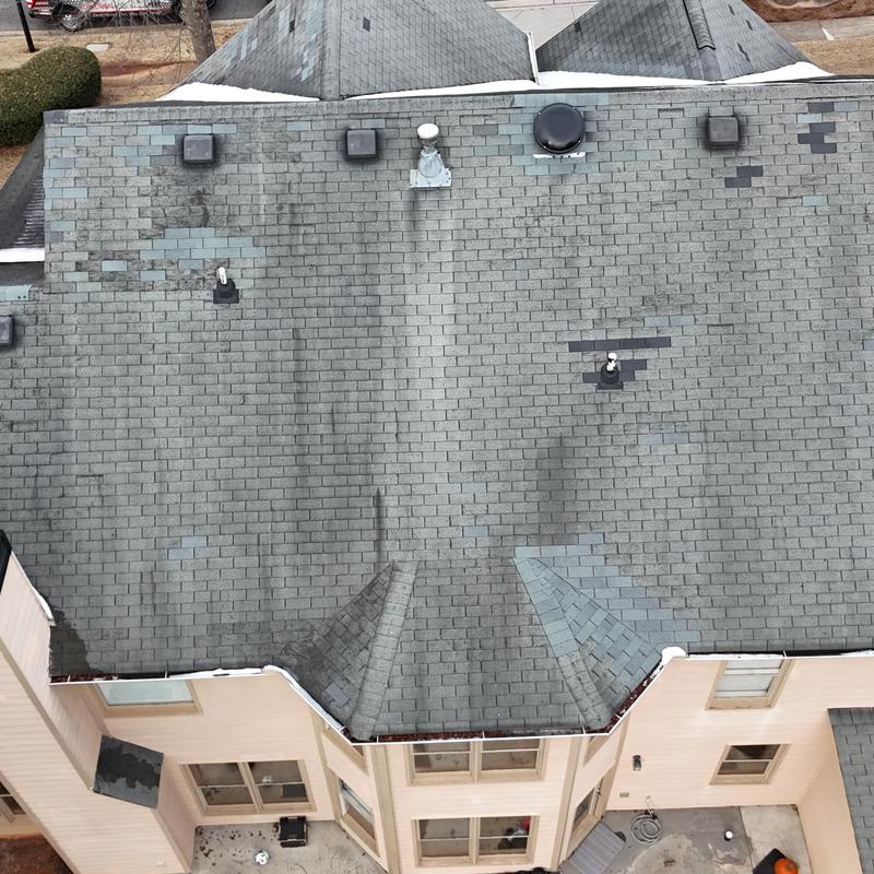 Three-tab roof with missing shingles and patches
