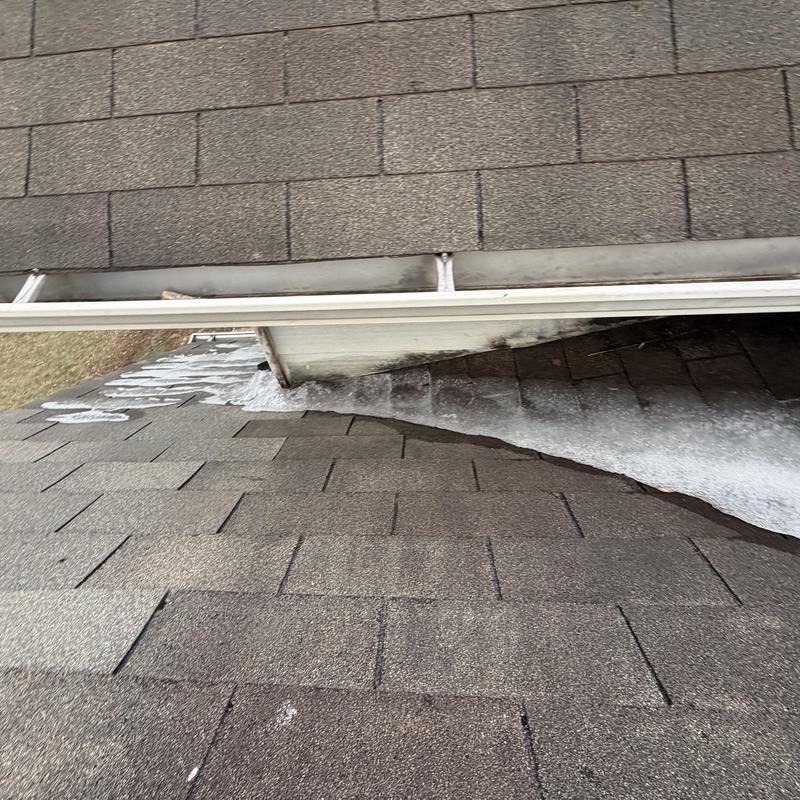 Dead valley roof flashing with ice buildup under gutter
