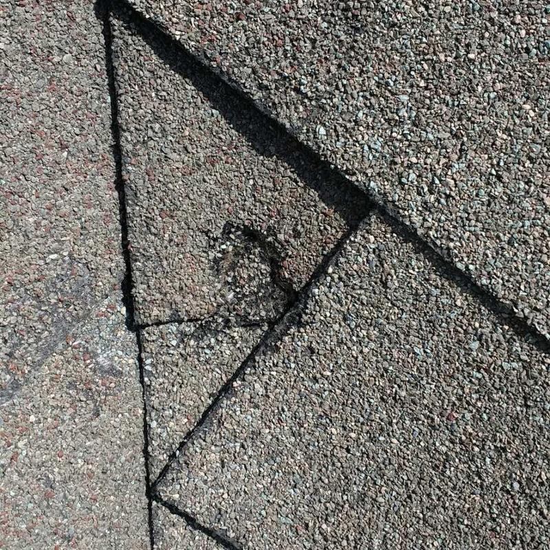 Asphalt shingle roof with hail damage close-up