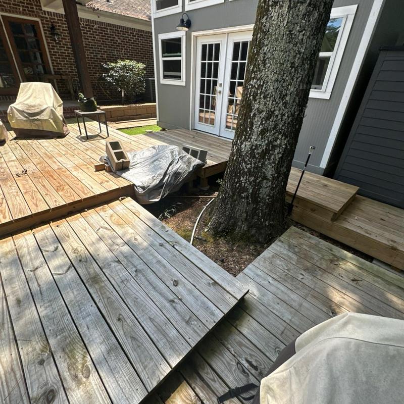 Wooden back deck around large tree with covered furniture Wooden back deck around large tree with covered furniture