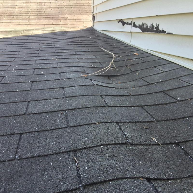 Black Shadow shingles buckling on residential roof section