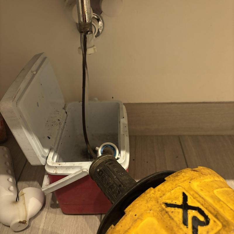 Bathroom sink drain snake machine in use