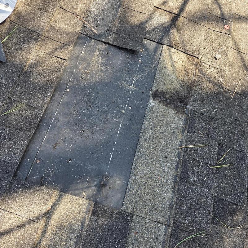Roof shingles with missing section and exposed underlayment