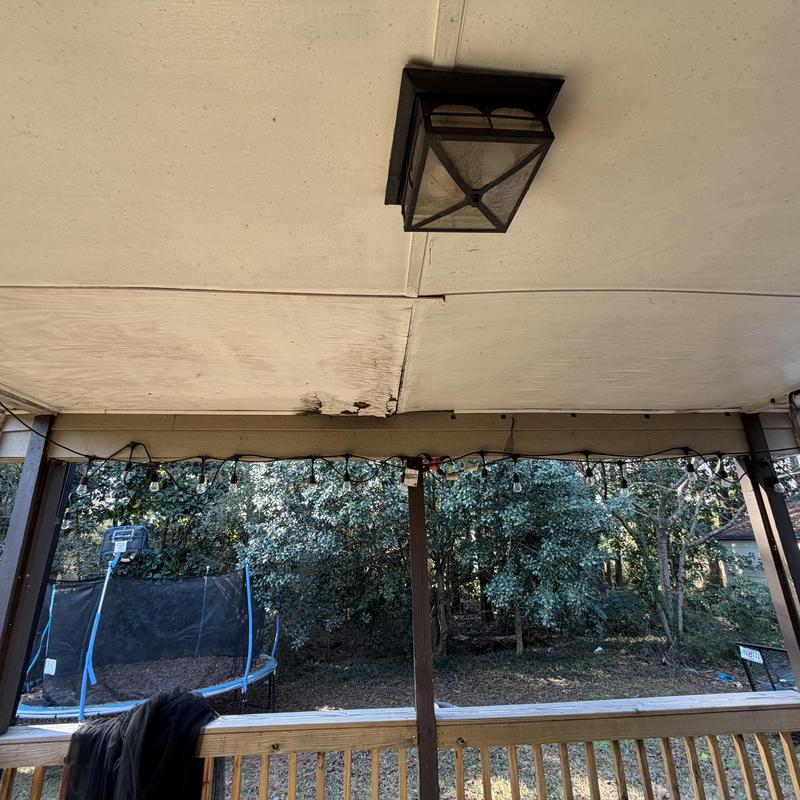 Porch plywood ceiling with water damage near light fixture