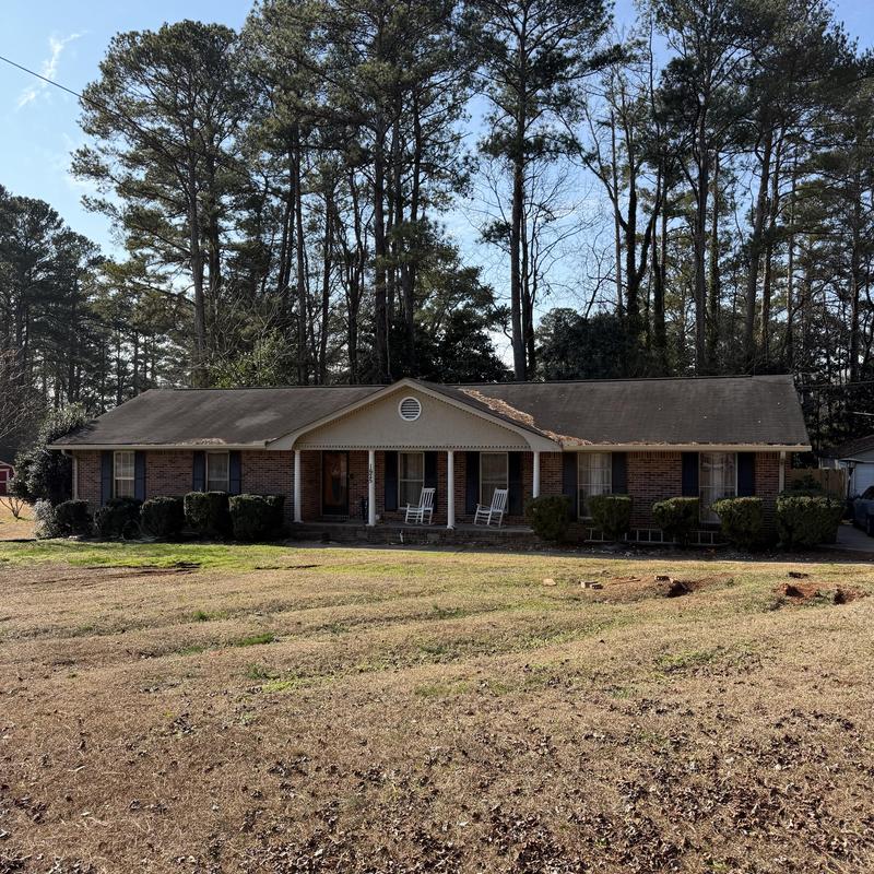 Roof with blown off shingles and damaged porch ceiling