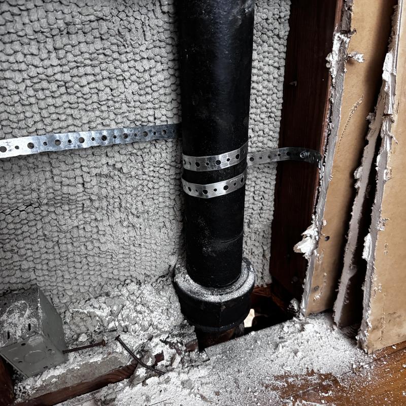 Cast iron pipe with old lead flange and pipe strap